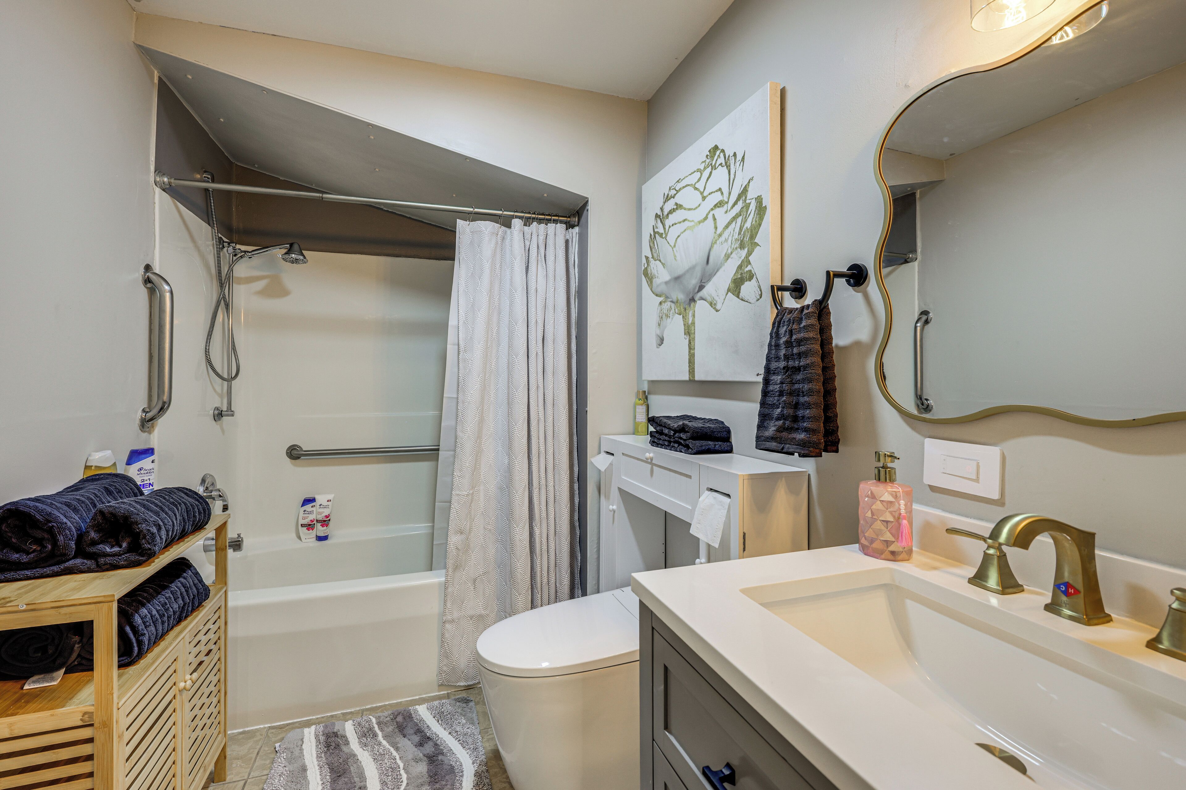 Een badkamer met een bad, toilet, wastafel en douche.