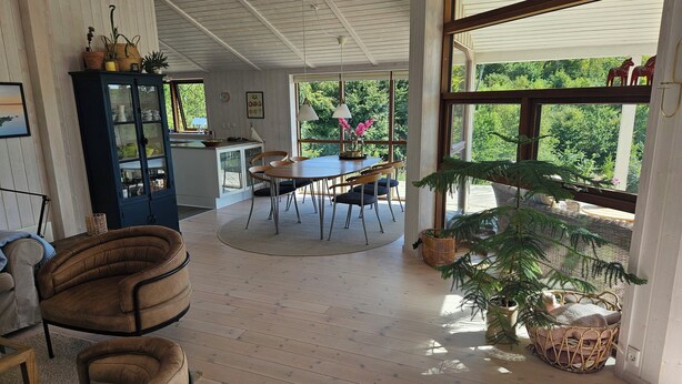 Una habitación amplia con comedor, un ventanal grande y una zona de estar acogedora.