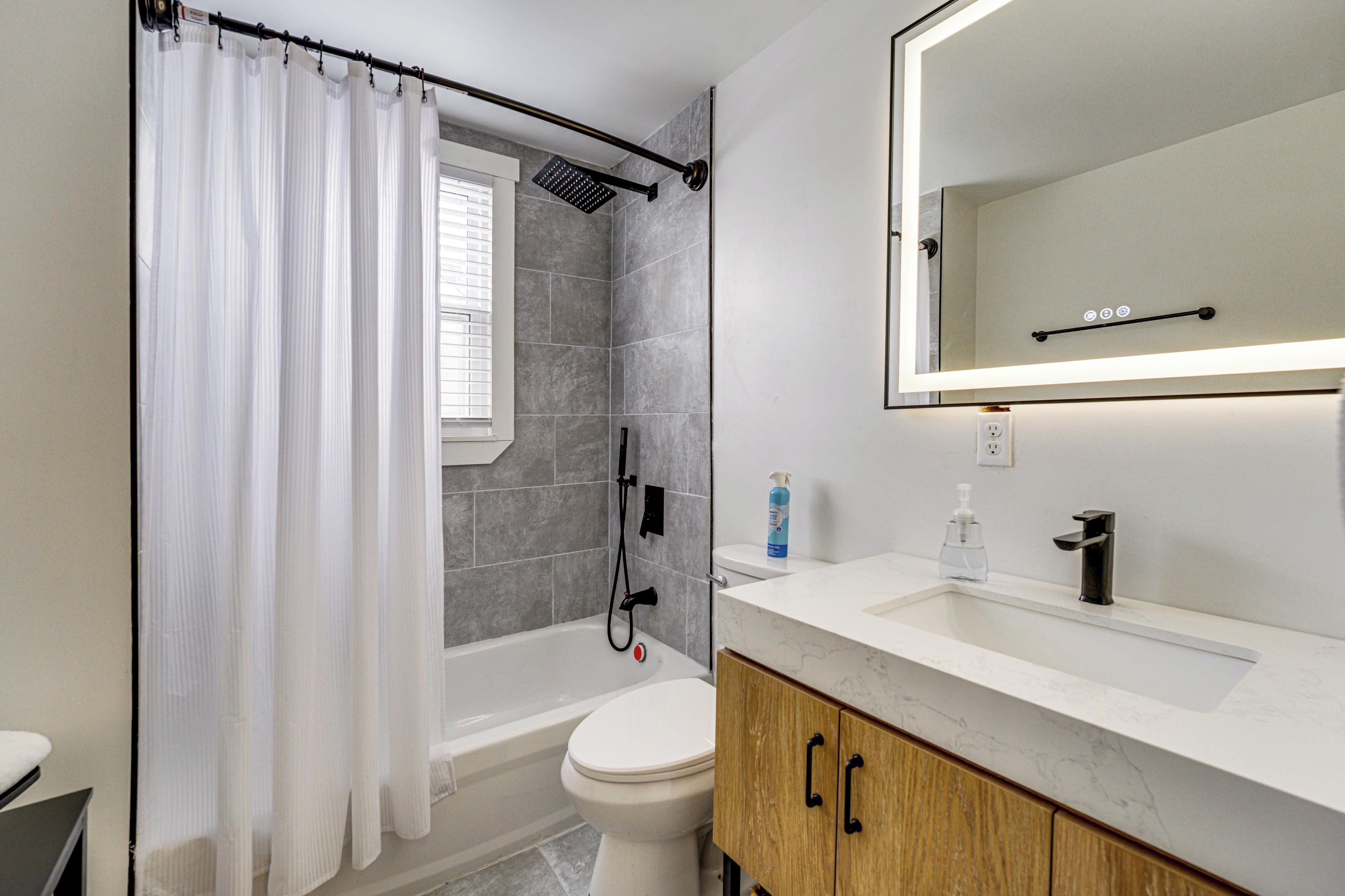 A modern bathroom with a shower, toilet, and vanity.