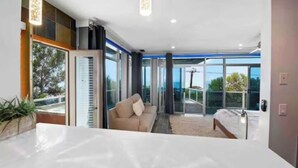 Ein modernes Schlafzimmer mit einem großen Bett, einer Couch und einer Glastür, die auf einen Balkon führt.