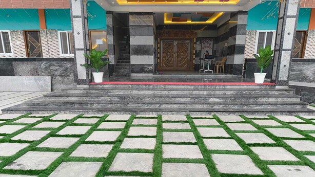 A building entrance with a patterned stone pathway and steps leading up to a door. - Annamalaiyar Mahal & Residency (Chengam)