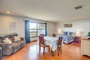 Ein geräumiges Zimmer mit Sofa, Esstisch, Bett und Schreibtisch.
