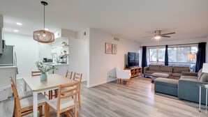 En moderne stue med spiseplads, sofa og tv.