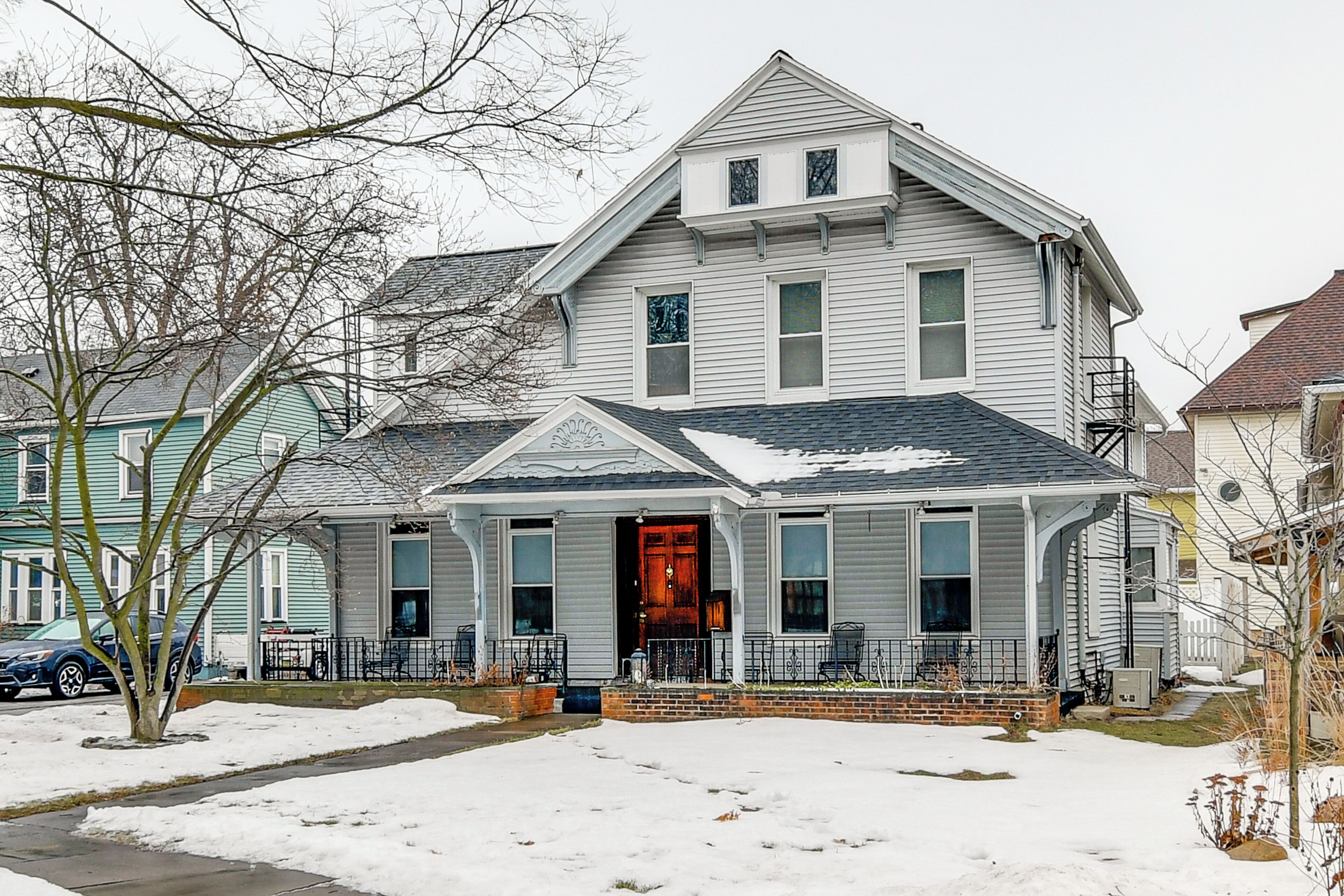 A two-story house with a front porch, a visible door, and a garage.