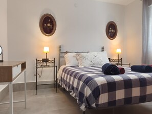 A neatly arranged bedroom with a bed, two bedside tables, a desk, and two wall-mounted lamps. - Nerja Sun Apartments Bahia 7 (Nerja)