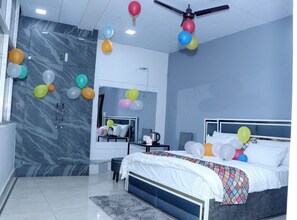 A modern bedroom with a bed, a desk, and a ceiling fan. - The City View- Hotel And Restaurant (Bhiwani)