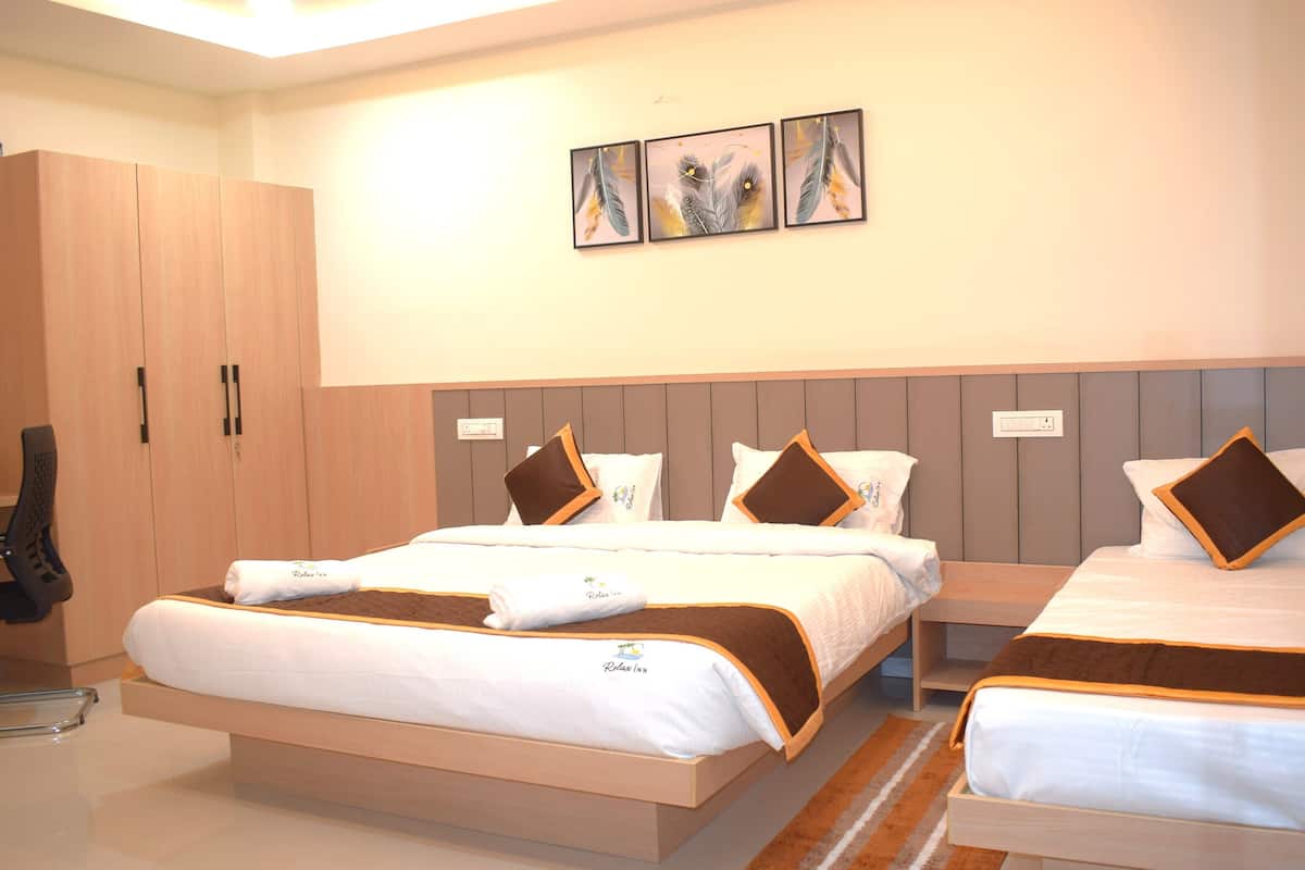 A modern hotel room with two beds, a wardrobe, and artwork on the wall.