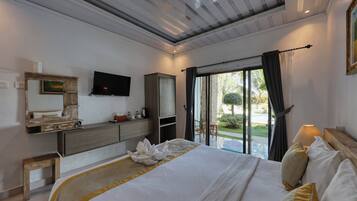 Habitación de hotel moderna con una cama grande, un televisor de pantalla plana, un armario de madera y vistas al exterior.