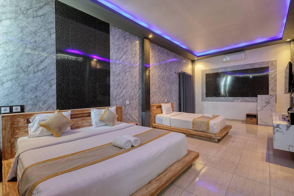Une chambre d’hôtel avec deux lits, des murs en marbre et une grande fenêtre.