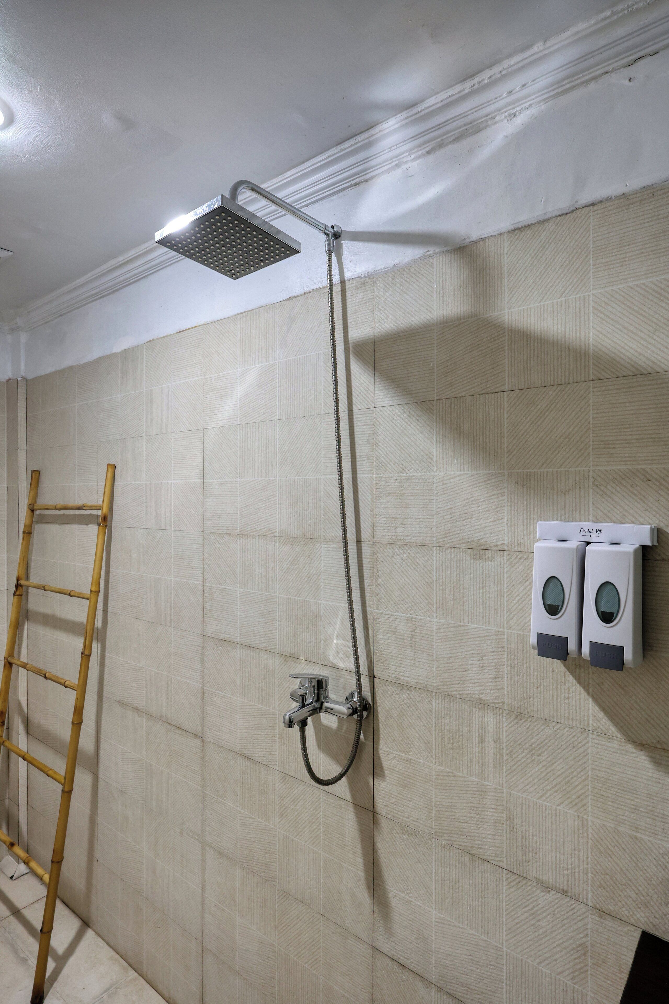 Un baño con ducha, toallero y secador de manos.
