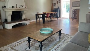 Ein Wohnzimmer mit Kamin, Essbereich und einer Couch.