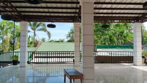 A covered outdoor area with a bench, columns, and a fence. - Tayud Hotel by Hiverooms (Liloan)
