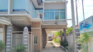 A gated entrance to a hotel with a covered walkway leading to the main building. - Tayud Hotel by Hiverooms (Liloan)