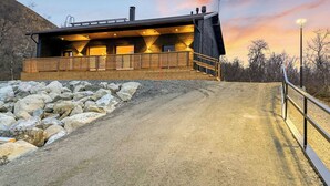 A modern building with a wooden deck and a gravel path leading to it. - Saanan taika by Interhome (Enontekiö)