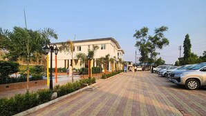 A paved walkway leading to a building with a flat roof and multiple windows. - Venkat's The MOUNTAIN by Redwings (Khalapur)