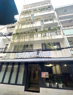 A building with a sign reading "DREAMLAND" at the ground level. - Dream Land (Cau Kho)