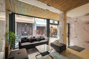 A modern interior with a sofa, a glass coffee table, and a patterned rug. - Dream Land (Cau Kho)