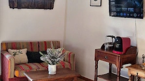 Un salon avec un canapé, une table basse et un téléviseur.