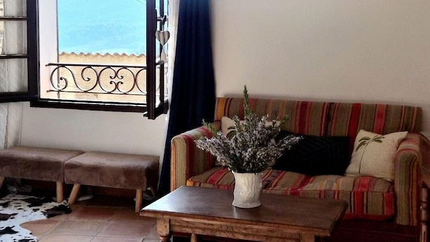 Un salon avec un canapé, une table basse et un élément décoratif au mur.