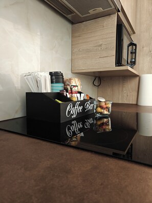 A kitchen with a coffee bar, a wooden cabinet, and a black countertop. - Marousi Serene Suite (Marousi)