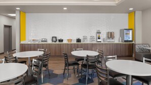 A modern kitchen area with a white brick backsplash, stainless steel appliances, and a digital menu display. - Microtel Inn & Suites by Wyndham Ephrata (Ephrata)