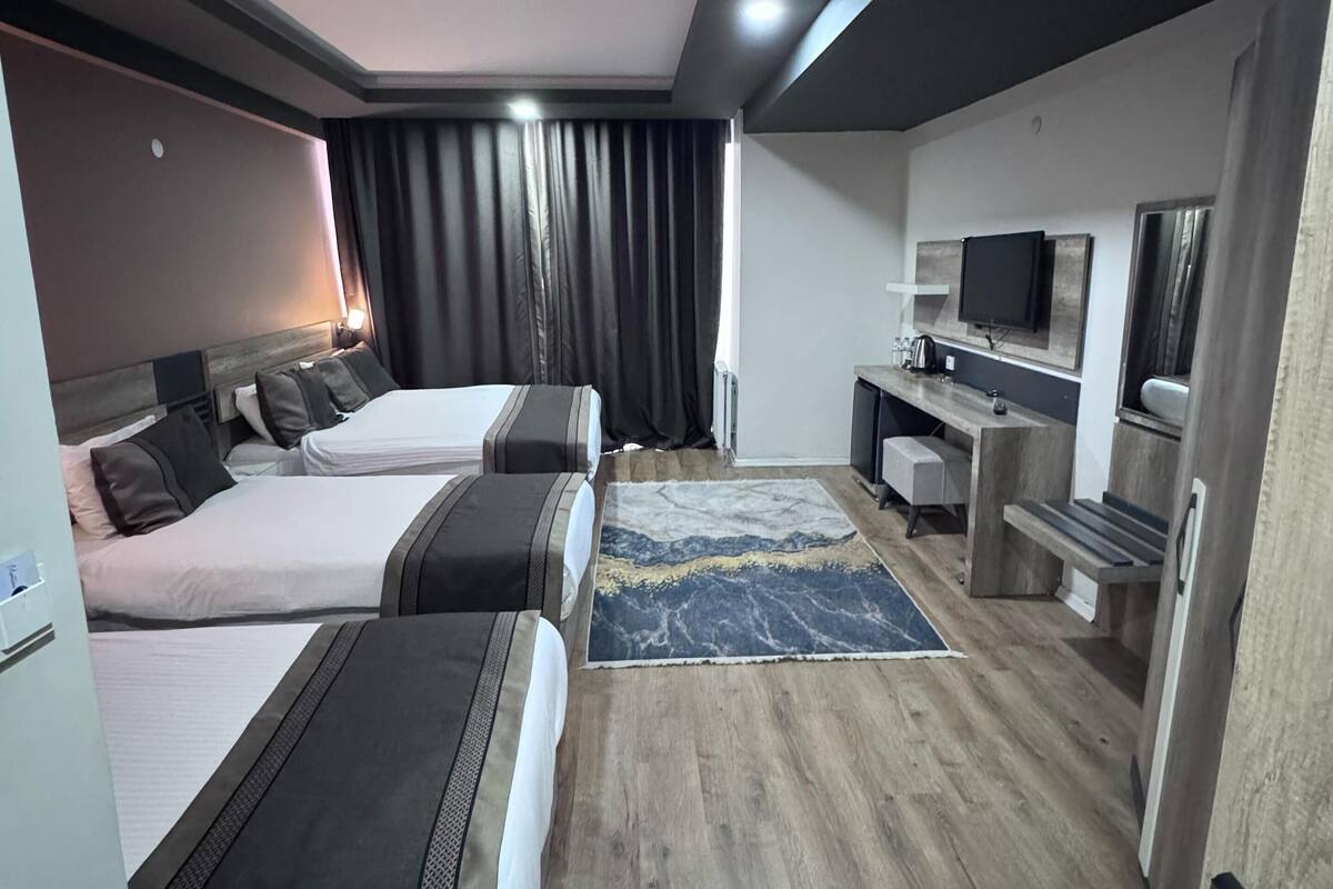 Een moderne hotelkamer met twee bedden, een bureau, een televisie en een badkamer.