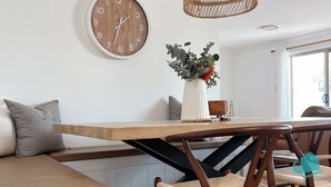 En matplats med ett träbord, en klocka och en vas med blommor.
