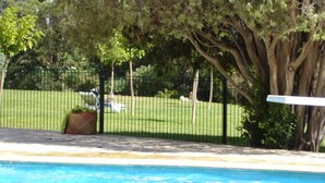 A swimming pool with a fenced area and trees in the background. - Seasonal rental saint Raphael Valescure 80m² 4 beds (Saint-Raphaël)