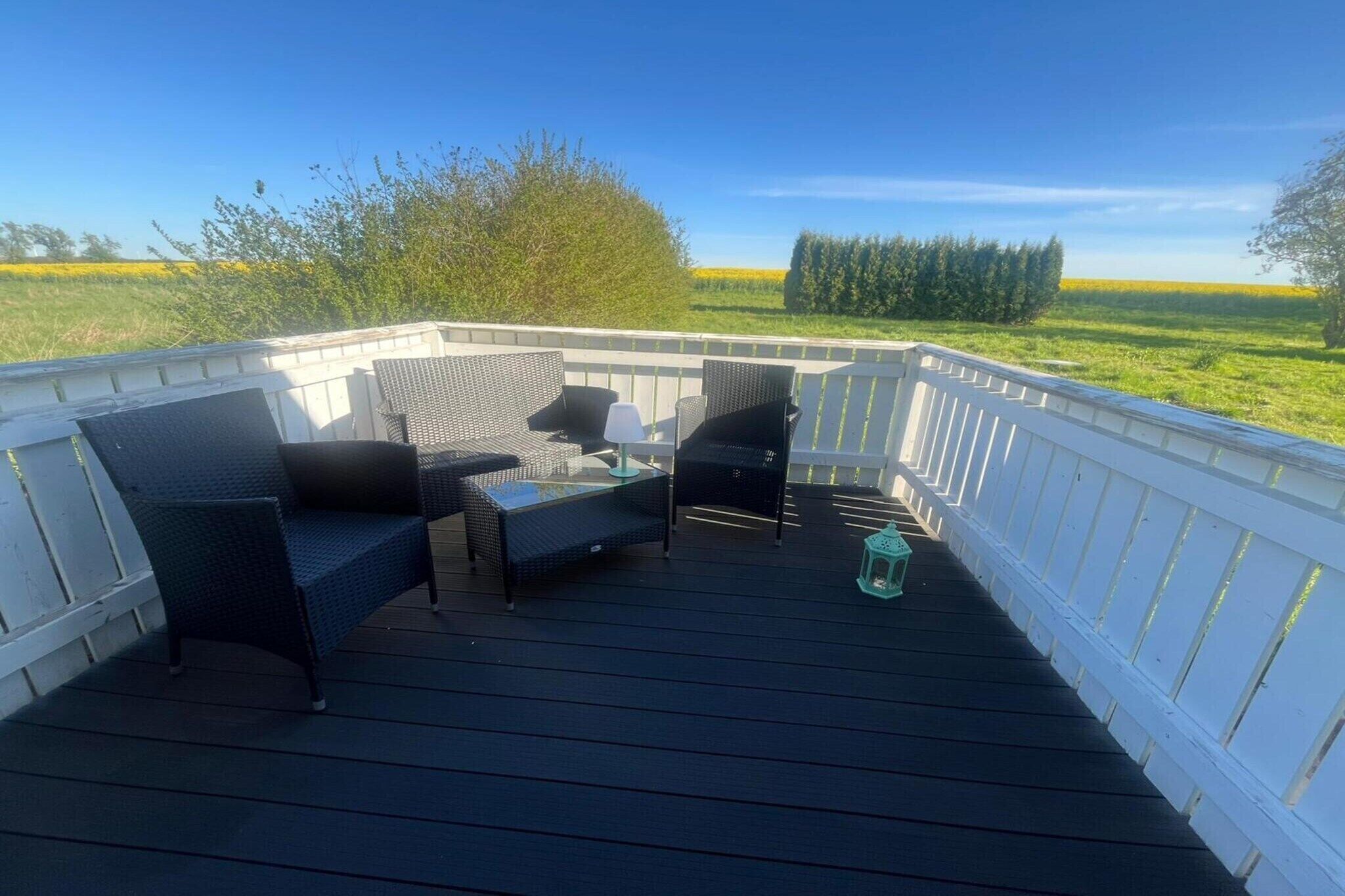 Una terraza techada con muebles de mimbre y un farol.