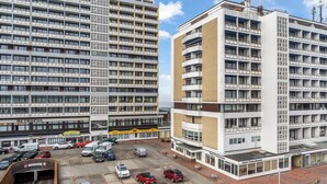 Een modern hotel met meerdere verdiepingen, een parkeerplaats en een duidelijke ingang.