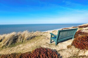 A bench by the sea with clear skies. - 62 m² 2-room vacation apartment in Kampen with a view of the sea, for up to 3 people (Kampen (Sylt))