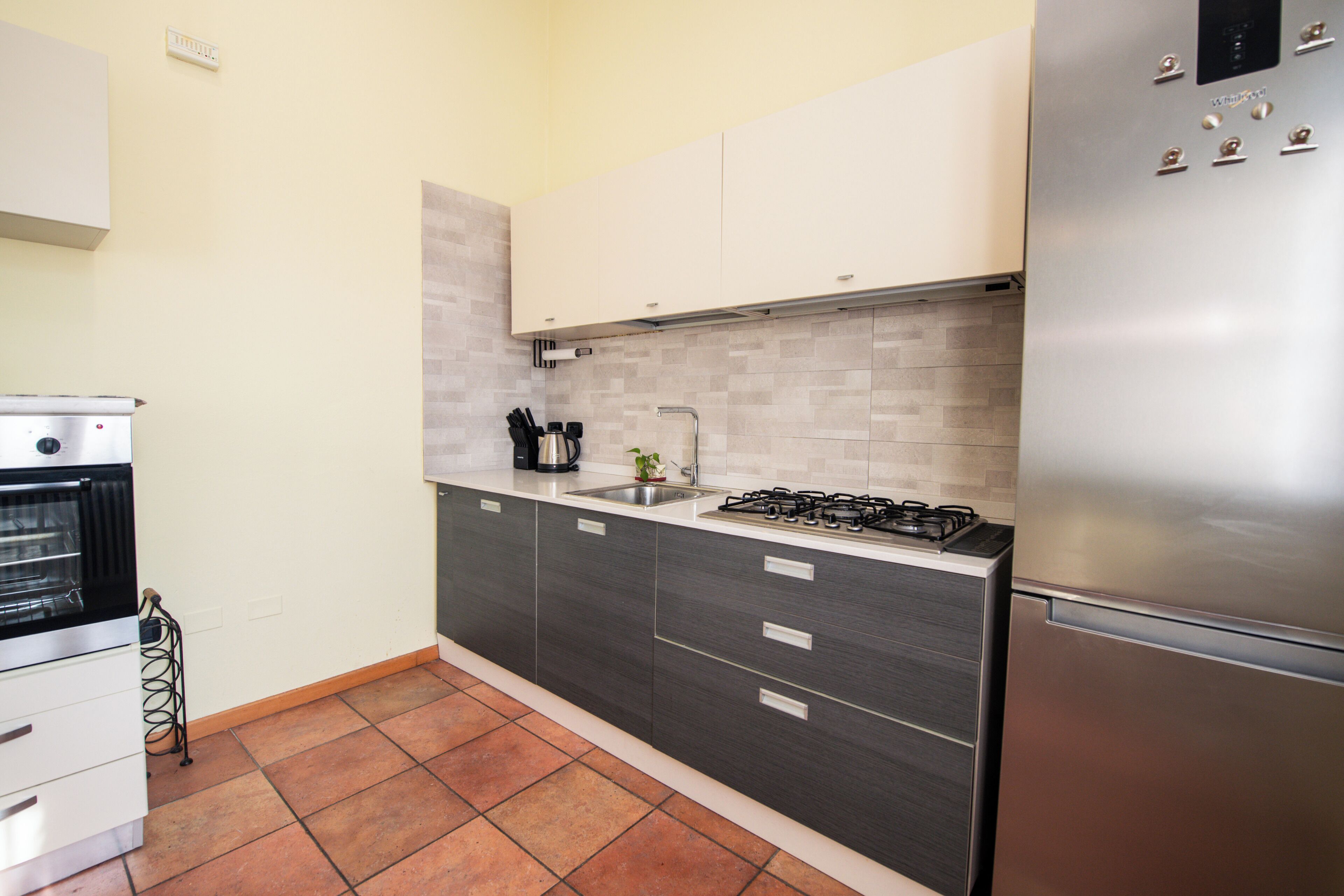 Une cuisine moderne équipée d’un réfrigérateur en acier inoxydable, d’un four encastré, d’une cuisinière à gaz et d’un évier.