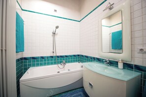 A bathroom with a bathtub, sink, and mirror. - Il Rifugio di Lonato (Lonato del Garda)