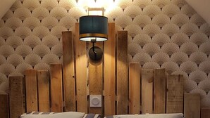Ein Schlafzimmer mit einem hölzernen Kopfende, zwei Kissen und einer Nachttischlampe.