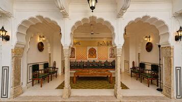 A traditional interior with a central seating area, ornate arches, and a patterned floor.