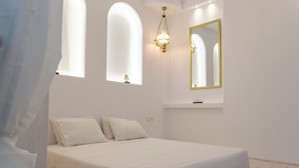 Una camera da letto con un letto, un lampadario, uno specchio e una finestra.