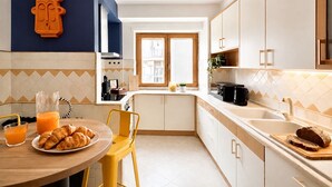 Une cuisine moderne avec un coin repas, une vue sur l’extérieur et un élément décoratif mural original.