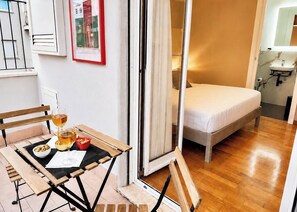 A bedroom with a bed, a bathroom with a sink, and a dining area with a table and chairs. - 100sqm Apt + Private Sauna | Walk to Vatican (Roma)