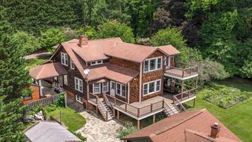 A two-story house with a balcony, a stone pathway, and a garden.