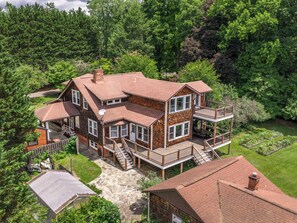 Ein zweistöckiges Haus mit einem Balkon, einem Steinweg und einem Garten.