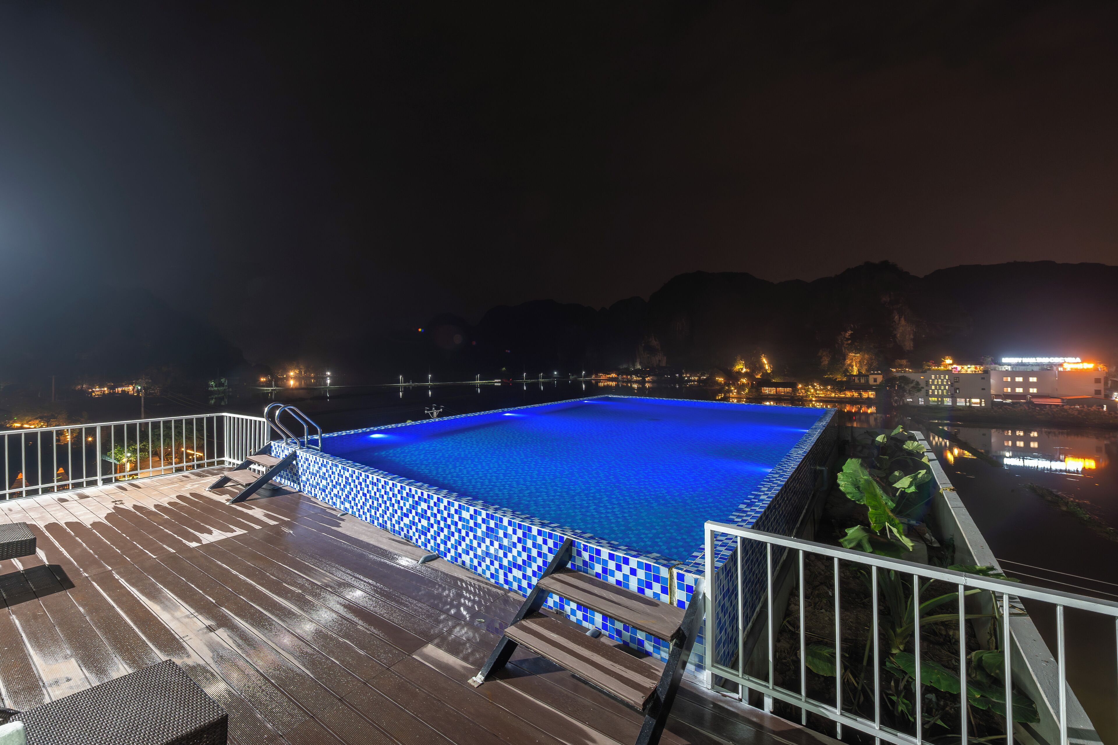 Een buitenzwembad, ligstoelen bij het zwembad