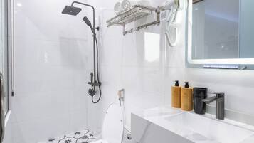 A modern bathroom with a toilet, shower, and vanity.