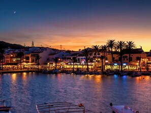A waterfront hotel with multiple buildings, a marina with boats, and palm trees.