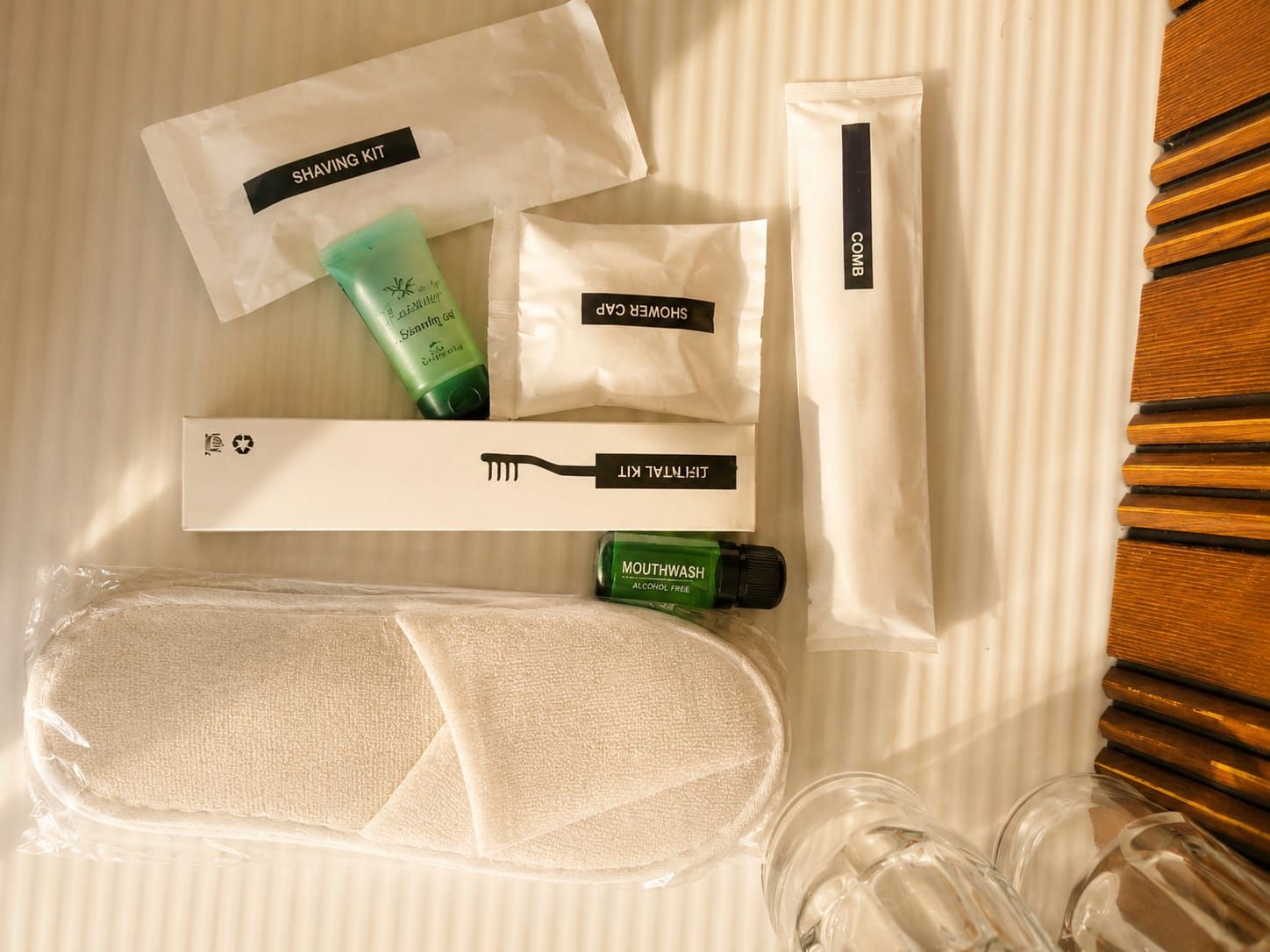 Un ensemble d’articles de toilette soigneusement rangés et un sac de toilette de voyage sont posés sur le lit.