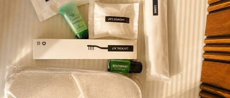 Un ensemble d’articles de toilette soigneusement rangés et un sac de toilette de voyage sont posés sur le lit.