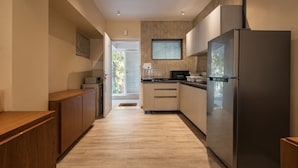 Una cucina moderna con mobili in legno, un frigorifero in acciaio inossidabile e un forno a microonde.