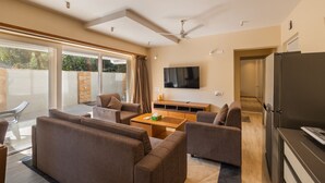 Un soggiorno moderno con una televisione a schermo piatto, una ventola a soffitto e una porta scorrevole in vetro che dà su un patio.