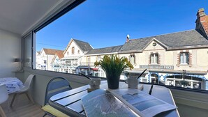 A balcony with a table, chairs, a map, and a potted plant. - Résidence de la Mer by Interhome (La Bernerie-en Retz)