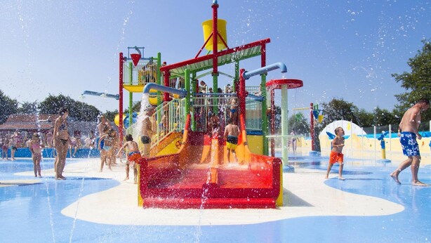 A water park with a central water feature and multiple play structures.