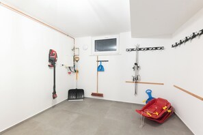 A clean, well-organized utility room with a window, a mounted coat rack, and various tools and equipment. - Hiking & Wellness · Sauna, Hot Tub, Fireplace (Winterberg)